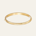 Gold bangle on a light beige background. The Nurture Classic Bangle is the definition of timeless jewellery. With its sleek, polished gold silhouette, it's the foundation piece that anchors your bracelet stack and move with you from day to night.&nbsp;

On the inside, engraved discreetly for only the wearer to see, are the words 'Nurture Your Mettle'&nbsp;a subtle nod to our ethos and a quiet reminder carried with you daily.